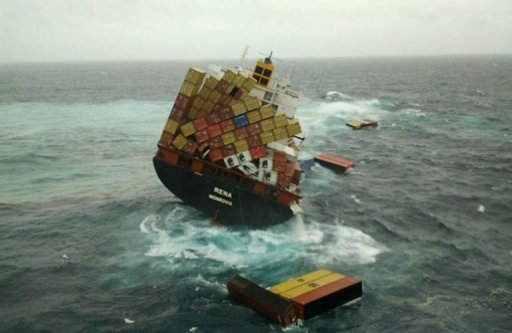 Container ship at sea with containers leaning over and falling off into the ocean